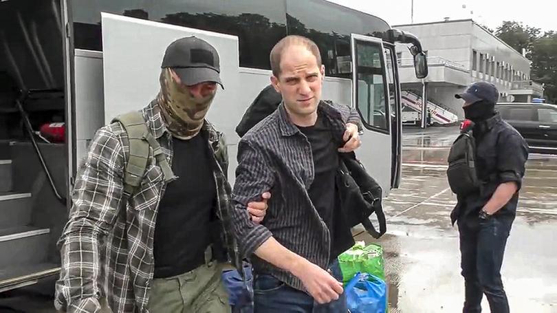 Wall Street Journal reporter Evan Gershkovich being escorted by a Russian Federal Security Service agent as they arrive at an airport outside Moscow, Russia. 