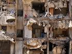 A man watches rescuers sift through the rubble as they search for people still missing at the site of Friday's Israeli strike in Beirut's southern suburbs.