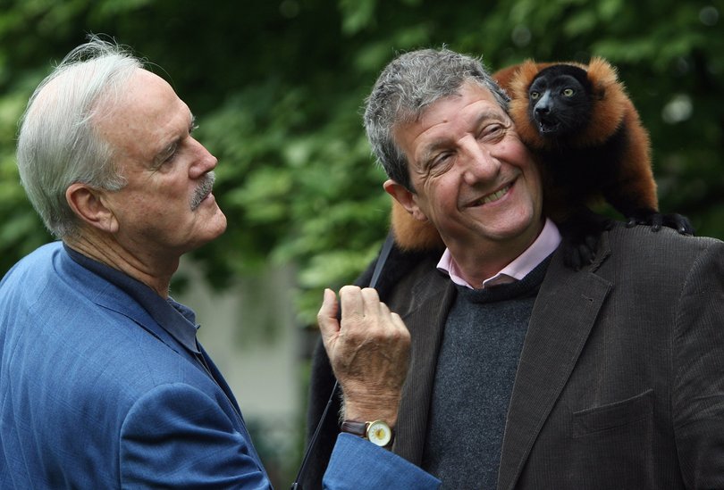 Actor John Cleese and Chris Serle look at a red ruffed lemur at Bristol Zoo on July 22 2008.