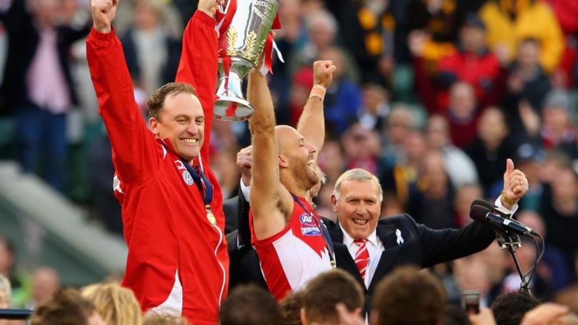 John Longmire and Jarrad McVeigh celebrate the 2012 premiership, with club legend Bobby Skilton.