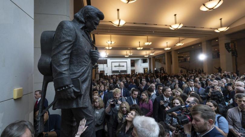 People crowd around after the unveiling of a bronze statue of Johnny Cash in Washington.