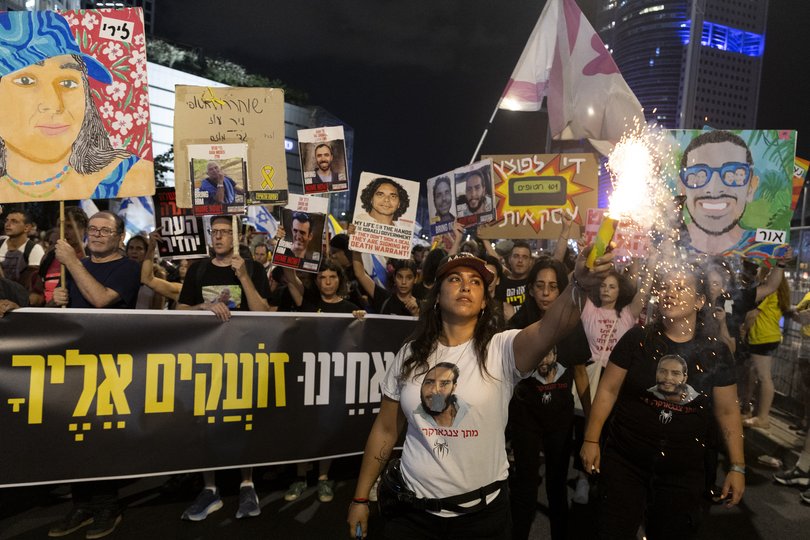 TEL AVIV, ISRAEL - SEPTEMBER 21: Families of hostages held in the Gaza Strip and supporters use smoke torches as they are taking part in a rally calling for a hostage deal on September 21, 2024 in Tel Aviv, Israel. Israel offers a new proposal to end war, let Sinwar leave if all hostages freed at once.(Photo by Amir Levy/Getty Images)