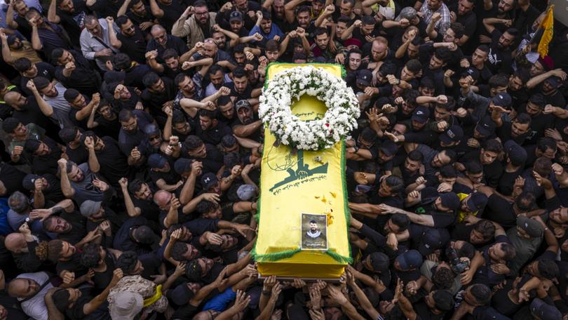 Hezbollah supporters carry a coffin at the funeral of two comrades killed Wednesday in the second wave of explosions in Beirut, Lebanon, Sept. 19, 2024. (Diego Ibarra Sanchez/The New York Times)