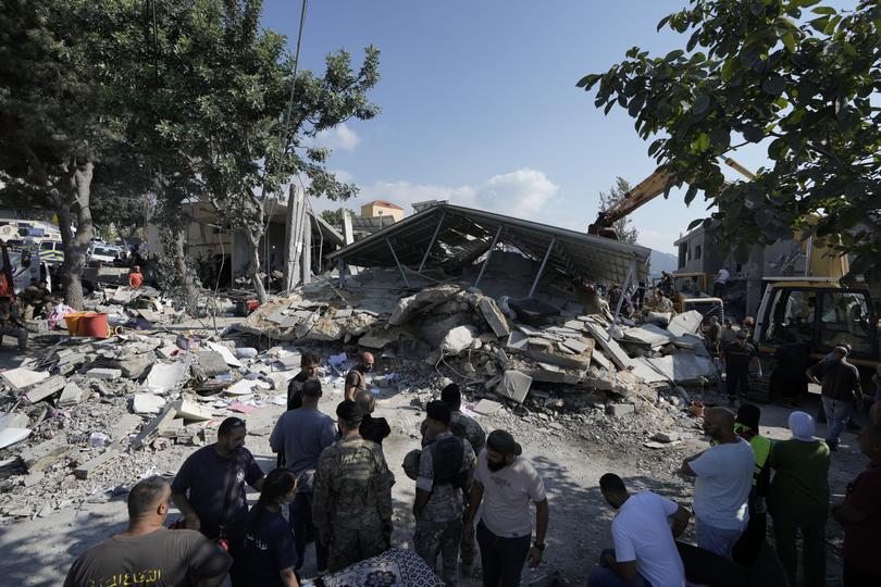 Residents and emergency workers arrive at the scene of an Israeli airstrike in the town of Maisara, north of Beirut, Wednesday, Sept. 25, 2024. 