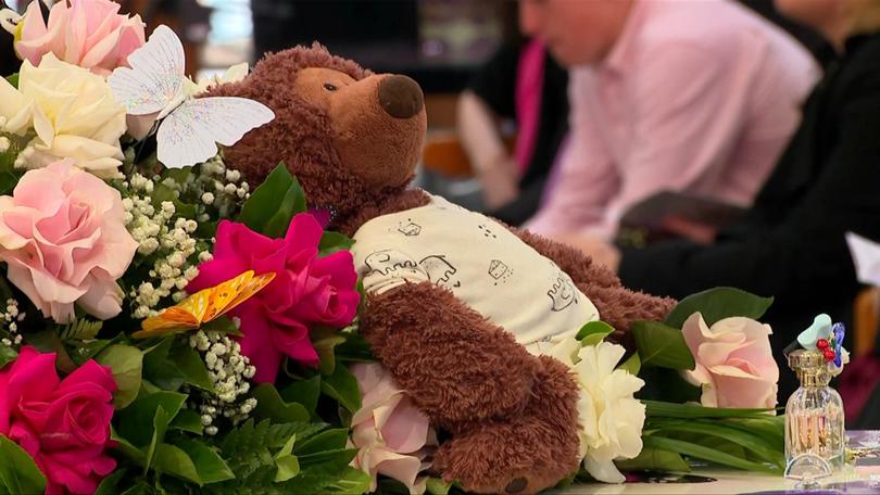 A teddy on the casket at Charlotte’s funeral.