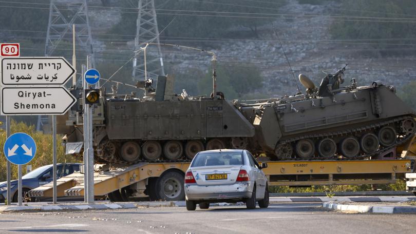 A lorry transports Israeli armoured vehicles in northern Israel near the border with Lebanon.