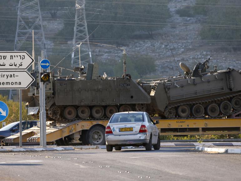 A lorry transports Israeli armoured vehicles in northern Israel near the border with Lebanon.