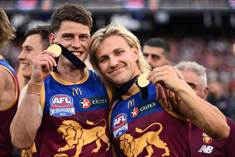 Jarrod Berry and Kai Lohmann of the Lions pose for photo with their premiership medals.