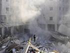 A man stands on the rubble of buildings near the site of the assassination of Hezbollah leader Hassan Nasrallah in Beirut's southern suburbs, Sunday, Sept. 29, 2024. (AP Photo/Hassan Ammar)