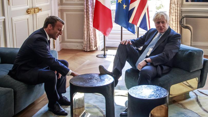 French President Emmanuel Macron, left, talks to Britain's then-PM Boris Johnson during their meeting in Paris in 2019. 