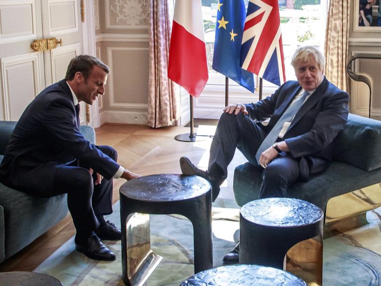 French President Emmanuel Macron, left, talks to Britain's then-PM Boris Johnson during their meeting in Paris in 2019. 