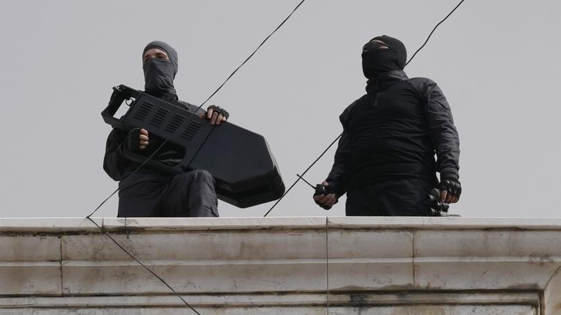 Hezbollah fighters stand guard on a building rooftop.