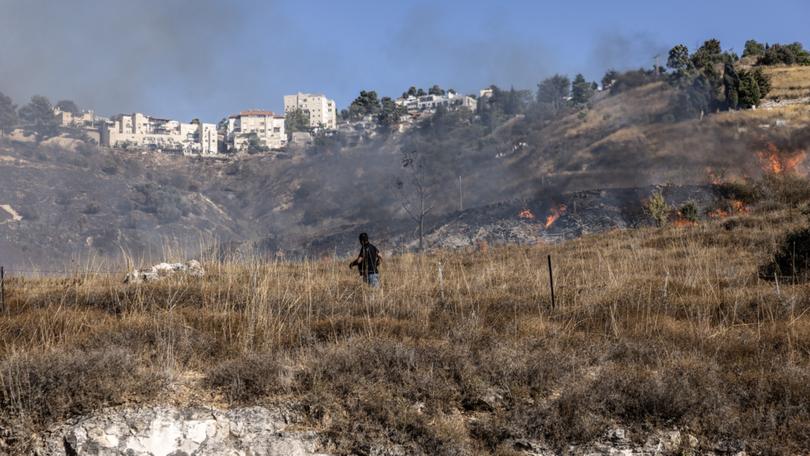 A man on the Israeli side of the Israel-Lebanon border films the aftermath of a rocket attack on Sept. 21. (MUST CREDIT: Heidi Levine for The Washington Post)