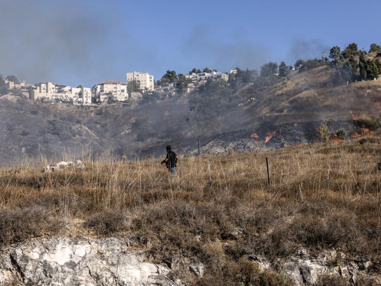 A man on the Israeli side of the Israel-Lebanon border films the aftermath of a rocket attack on Sept. 21. (MUST CREDIT: Heidi Levine for The Washington Post)