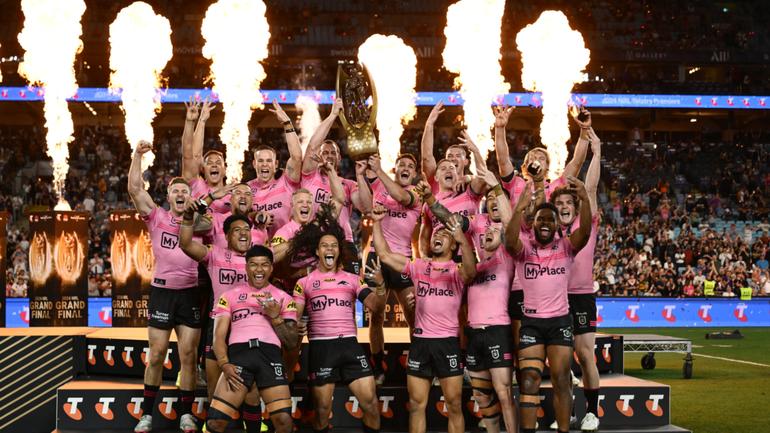 Isaah Yeo and Nathan Cleary of the Panthers hold aloft the Provan-Summons Trophy with a jubilant Penrith team.