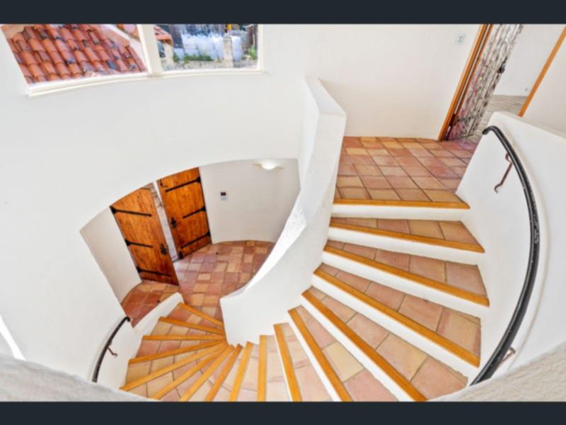 The house features arched, white rendered walls and Spanish tiles.