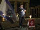 A woman reads the names of the victims of the October 7 attack at the Brandenburg Gate in Berlin. (AP PHOTO)