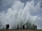 People take photos of the spray from waves crashing against the Malecon seawall, brought by the passing of Hurricane Milton in the Gulf of Mexico, in Havana, Cuba, Wednesday, Oct. 9, 2024. (AP Photo/Ramon Espinosa)