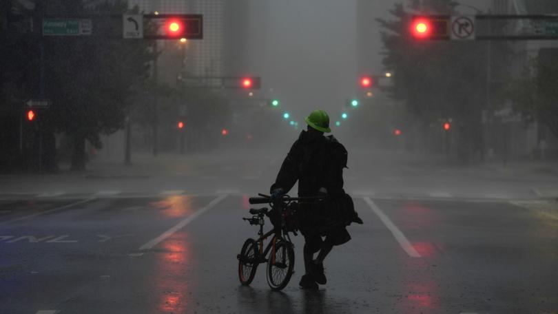 Ron Rook walks through windy and rainy conditions on a deserted street in downtown Tampa, Florida, during the approach of Hurricane Milton.