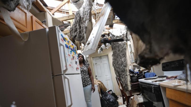 A resident in a damaged kitchen