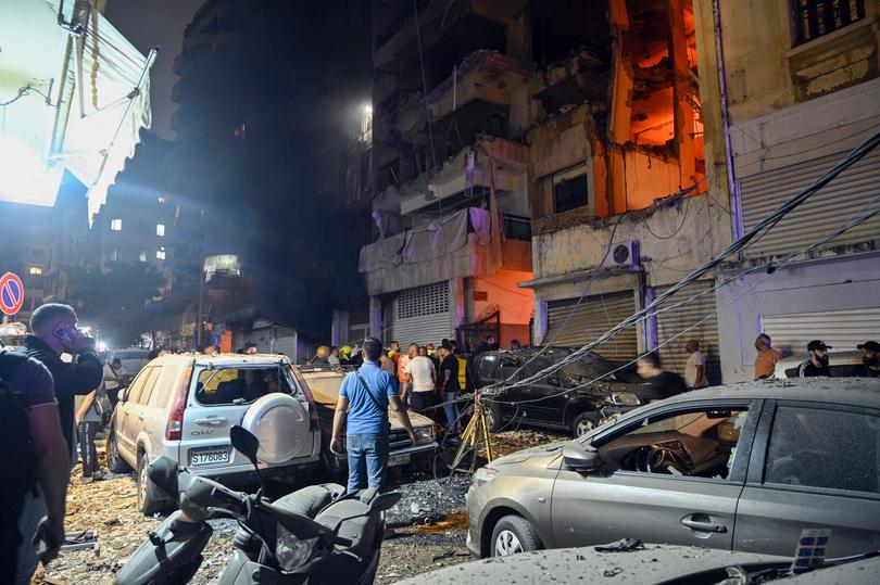 People gather in front of a damaged building after an Israeli military strike in the Nuwayri neighborhood of Beirut, Lebanon, October 10, 2024.