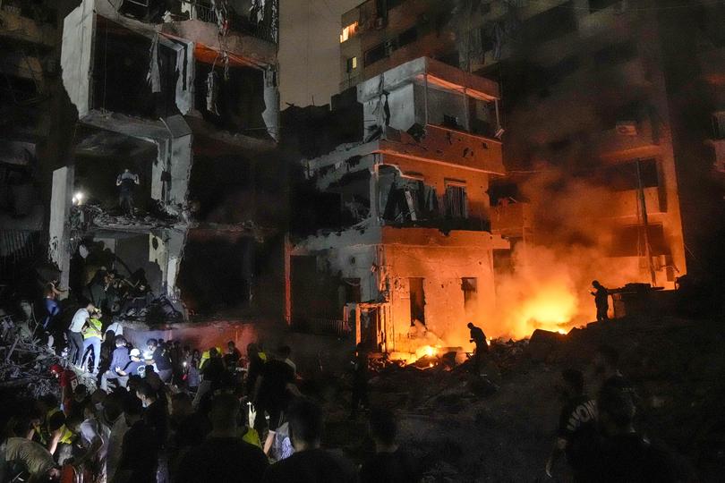 People gather in front of destroyed buildings hit by an Israeli airstrike in central Beirut.