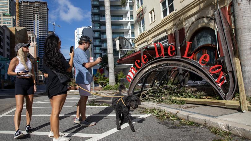 People check out damage from Hurricane Milton at the Ponce de Leon in St. Petersburg.