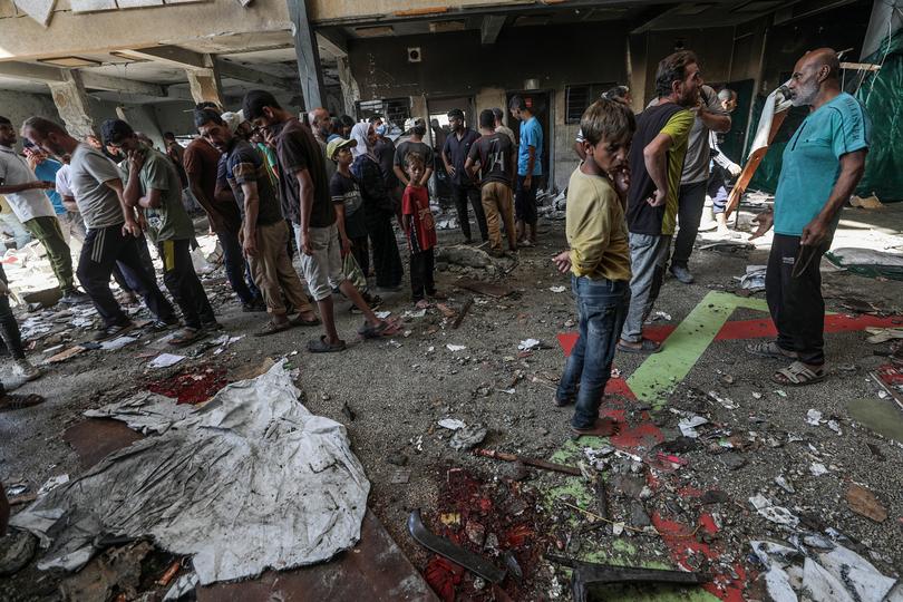 Displaced Palestinians inspect the damage at the destroyed Rufaida School, in Deir al-Balah, central Gaza Strip on October 10. 