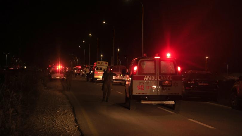 Emergency services personnel attend the scene of a drone strike in Binyamina, Israel.