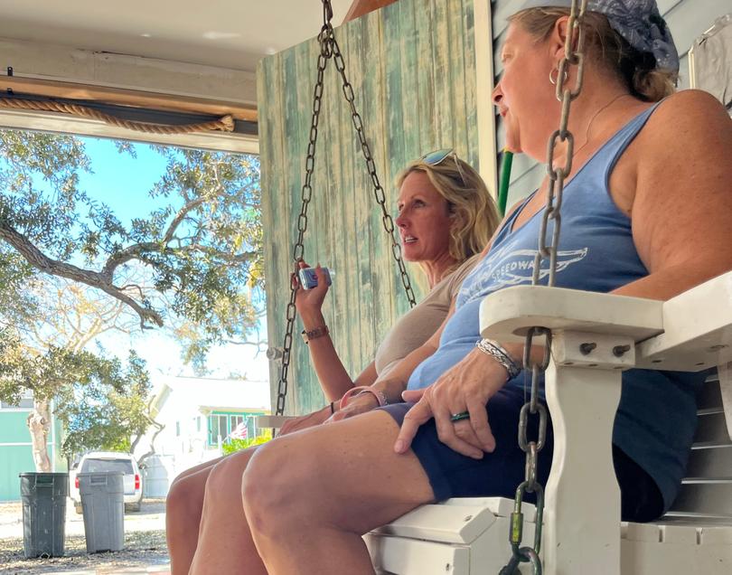 Melody King, left, and Dana Raco sit on Raco's porch on Oct. 10, in the aftermath of Hurricane Milton. 