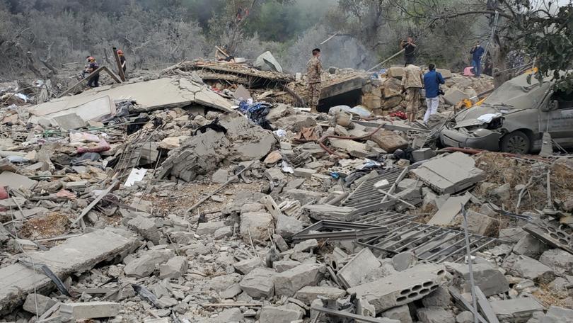 Lebanese emergency teams, soldiers and civilians conduct search and rescue operations after an Israeli air strike on the village of Aitou.