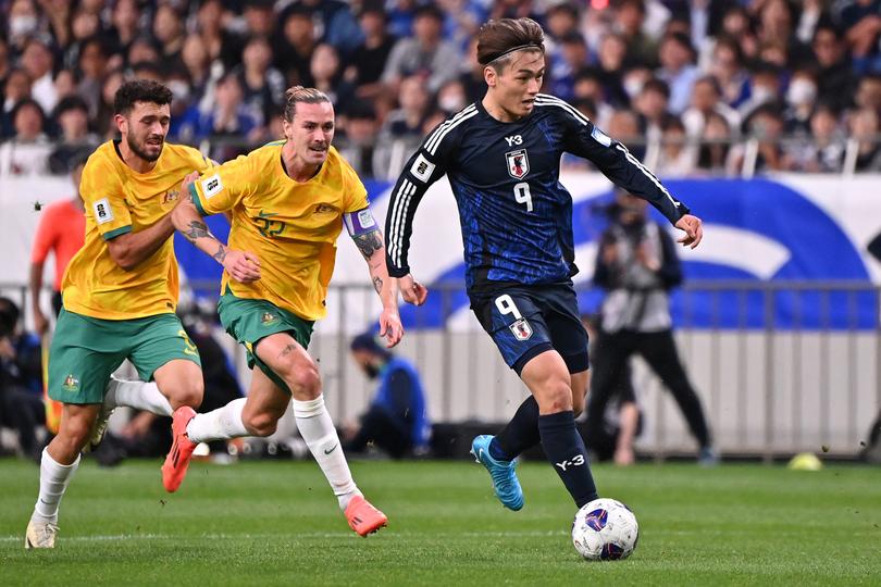 Ayase Ueda of Japan controls the ball against Jackson Irvine of Australia.