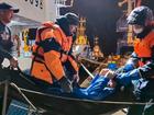 Emergency workers pull Mikhail Pichugin ashore after he was rescued by a fishing vessel. 