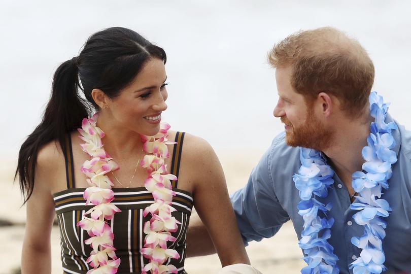 FILE - In this Friday, Oct. 19, 2018 file photo, Britain's Prince Harry and Meghan, Duchess of Sussex meet with a local surfing community group, known as OneWave, raising awareness for mental health and wellbeing in a fun and engaging way at Bondi Beach in Sydney, Australia. Sunday, May 19, 2019 marks the first wedding anniversary of the besotted couple.  (Chris Jackson/Pool Photo via AP, File)