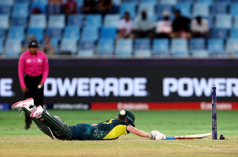 DUBAI, UNITED ARAB EMIRATES - OCTOBER 17: Beth Mooney of Australia dives to make ground as she is run out by South Africa during the ICC Women's T20 World Cup Semi-Final between Australia and South Africa at Dubai International Stadium on October 17, 2024 in Dubai, United Arab Emirates. (Photo by Francois Nel/Getty Images)