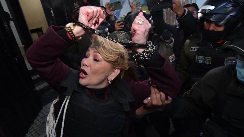 Former Bolivian president Jeanine Añez leaves the Miraflores women's prison in La Paz in handcuffs guarded by police officers to attend her trial on October 17, 2024. - A court in La Paz will begin a criminal trial on Thursday against former Bolivian president Jeanine Áñez, for allegedly planning a ‘coup d'état’ against the then president, Evo Morales, in 2019. (Photo by DANIEL MIRANDA / AFP) DANIEL MIRANDA