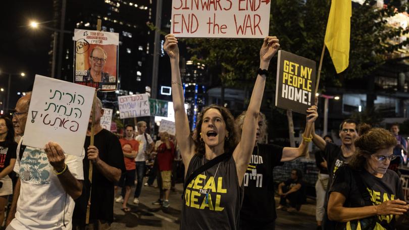 Deborah Galili, 43, holds a sign she made about the killing of Hamas leader Yahya Sinwar during a protest in Tel Aviv calling for an immediate cease-fire deal release of hostages held by Hamas on Thursday, Oct. 17, 2024. 