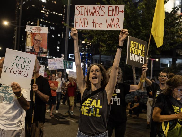 Deborah Galili, 43, holds a sign she made about the killing of Hamas leader Yahya Sinwar during a protest in Tel Aviv calling for an immediate cease-fire deal release of hostages held by Hamas on Thursday, Oct. 17, 2024. 