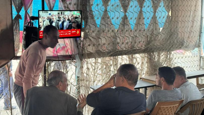 People gather to watch news on Yahya Sinwar’s fate, the day after Israel announced it had killed the Hamas leader, in a makeshift roadside cafe in Khan Younis, southern Gaza. War-weary Palestinians there expressed one emotion again and again: relief. 