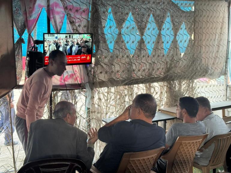 People gather to watch news on Yahya Sinwar’s fate, the day after Israel announced it had killed the Hamas leader, in a makeshift roadside cafe in Khan Younis, southern Gaza. War-weary Palestinians there expressed one emotion again and again: relief. 