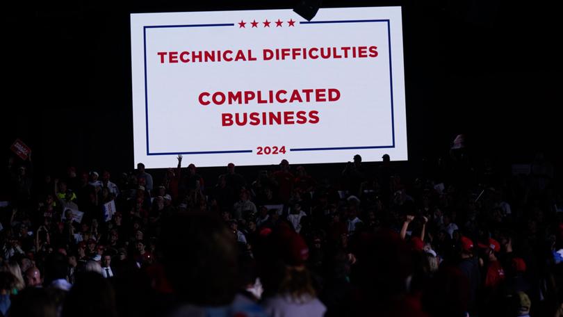 A screen makes note of technical difficulties when microphones stopped working during a Trump campaign event in Detroit.