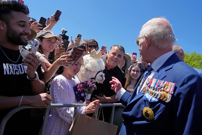 Britain's King Charles III chats with the owner of an alpaca before leaving the Australian War Memorial.