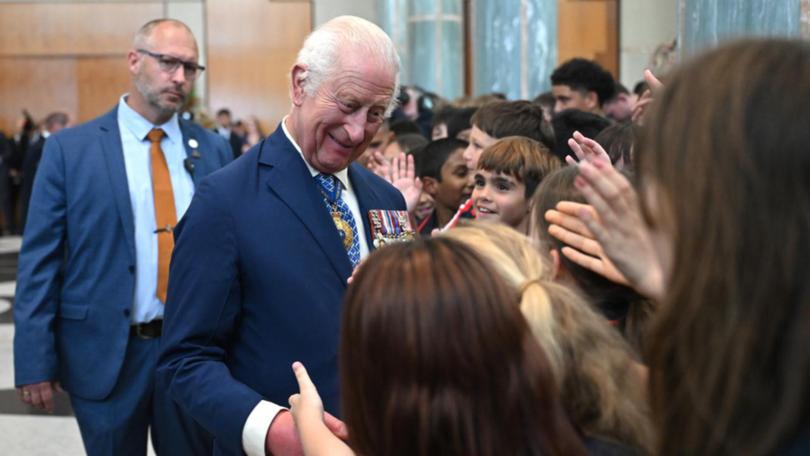 King Charles greets students after attending a parliamentary reception in Canberra. (Lukas Coch/AAP PHOTOS)