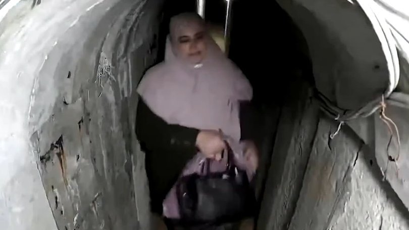 The wife of former Hamas leader Yahya Sinwar makes her way through a tunnel – deep beneath the streets of Gaza – clutching what looks like a Hermes Birkin bag worth £26,000 (AUD$50,000). 