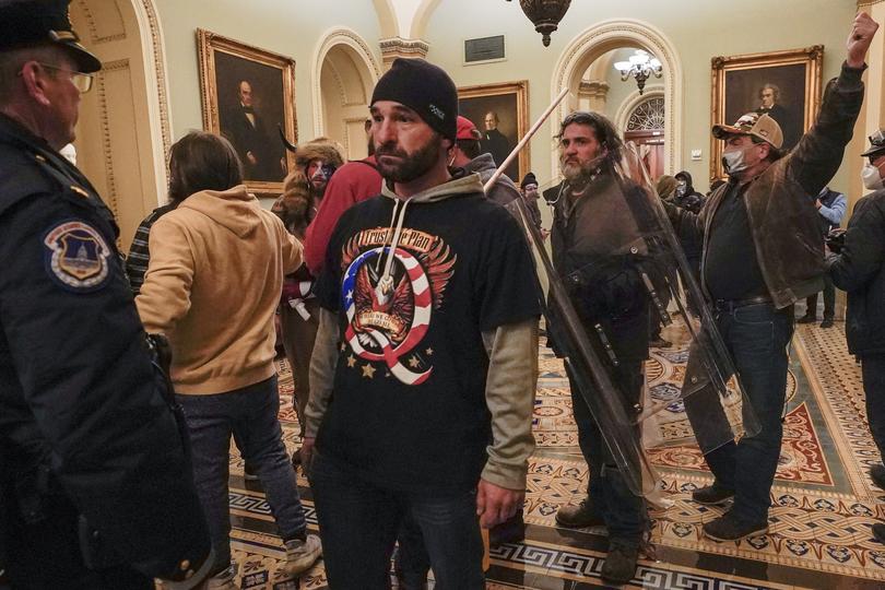 FILE - Rioters are confronted by U.S. Capitol Police officers outside the Senate Chamber inside the Capitol, Wednesday, Jan. 6, 2021, in Washington.  Speaker Kevin McCarthy?s decision to unleash a trove of Jan. 6 Capitol attack footage to Fox News? Tucker Carlson has launched a wholesale rewriting of the history of the deadly siege. Carlson aired the first installment of some 41,000 hours of security footage on his prime-time show and promised more Tuesday. (AP Photo/Manuel Balce Ceneta, File)