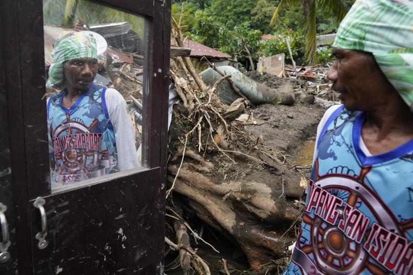 Marcelino Aringo speaks near his damaged house after a landslide triggered by Tropical Storm Trami struck homes, leaving several villagers dead in Talisay, Batangas province, Philippines on Saturday, Oct. 26, 2024. 