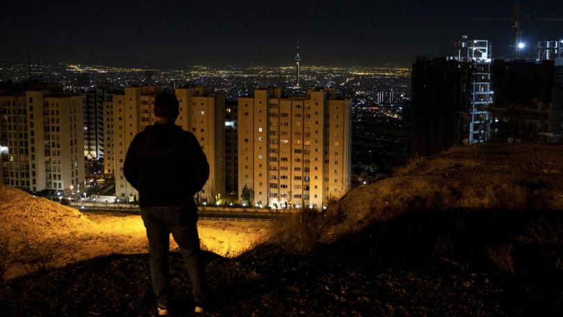 Looking out over Tehran after hearing the sound of explosions on Saturday, Oct. 26, 2024. IsraelÕs retaliatory attack on Iran on Saturday morning marked the start of a new and more dangerous phase in the two countriesÕ yearslong conflict, but it appeared, at least for now, to have stopped short of prompting an all-out war, analysts said. (Arash Khamooshi/The New York Times)