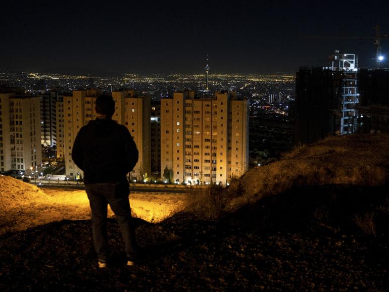 Looking out over Tehran after hearing the sound of explosions on Saturday, Oct. 26, 2024. IsraelÕs retaliatory attack on Iran on Saturday morning marked the start of a new and more dangerous phase in the two countriesÕ yearslong conflict, but it appeared, at least for now, to have stopped short of prompting an all-out war, analysts said. (Arash Khamooshi/The New York Times)