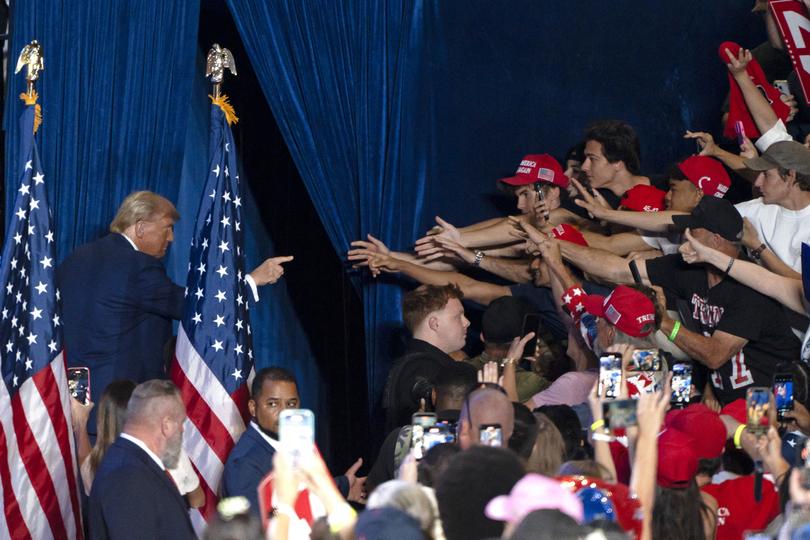 Former US President and Republican presidential candidate Donald Trump gestures at supporters as he exits the stage at the end of a campaign rally at Mullet Arena in Tempe, Arizona on October 24, 2024. (Photo by Rebecca NOBLE / AFP)