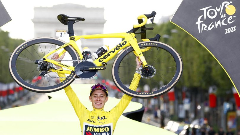 Jonas Vingegaard celebrates on the Champs-Elysees podium after winning the 2023 Tour de France